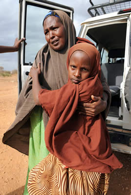 母親のデカさん（左）に支えられて立つリドワンちゃん。内戦に巻き込まれて負傷してから、母が娘のつえ代わりになってきた＝エチオピア・ドロアド近郊のボコルマヨ難民キャンプで２０１０年６月１１日、小松雄介撮影