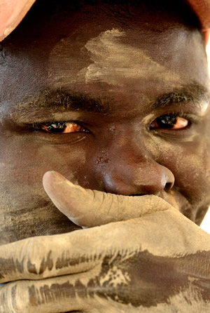掘削した岩石を機械で粉砕するマイガ・イサ君（１７）。粉じんで目は真っ赤に充血している