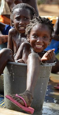 キャンプの水くみ場でバケツに入って水浴びをする女の子たち＝ブルキナファソ・ゴーデボー難民キャンプで２０１３年３月４日、大西岳彦撮影
