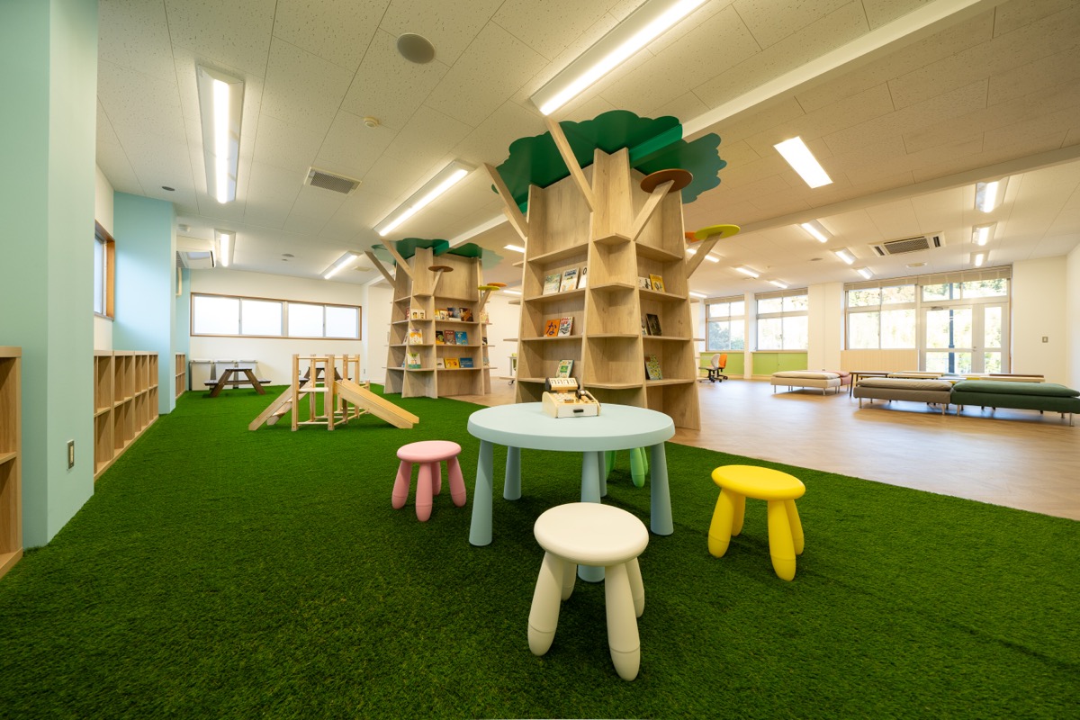 さんむ西小の館内、木のツリー型本棚がある子ども向けスペース