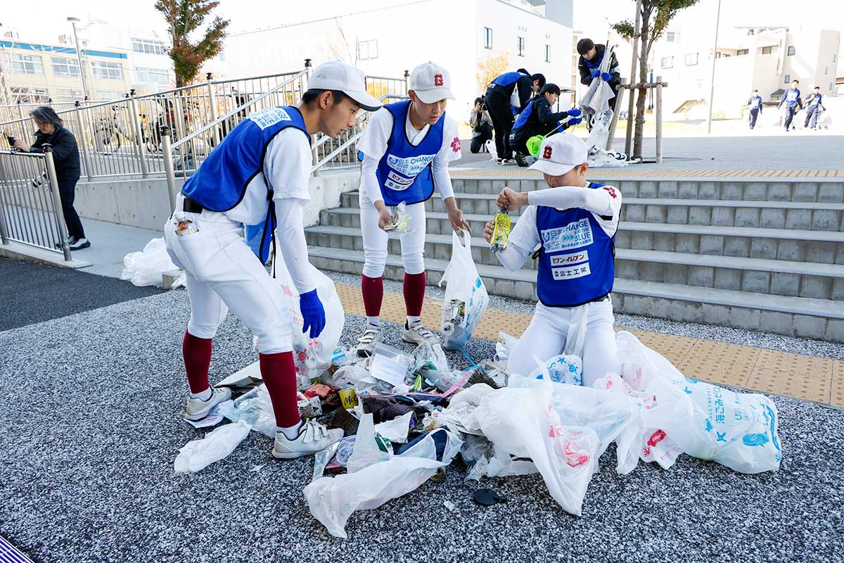 拾ったごみを分別するユニフォーム姿の高校生