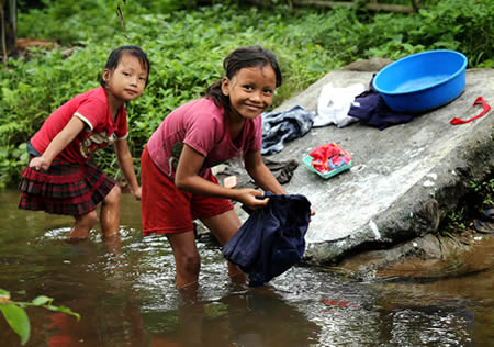 キャンプ内を流れる川で洗濯をする女の子たち