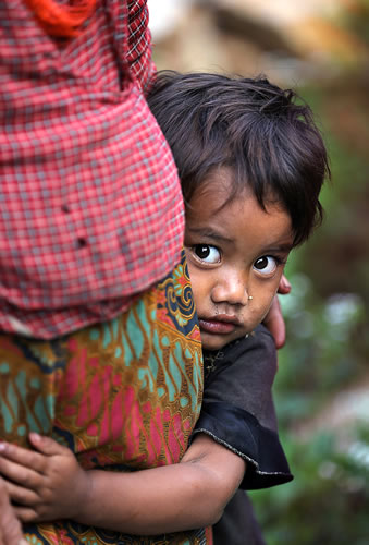 住んでいた家屋が倒壊し仮設住宅で生活する少女は、母親にしがみつき離れようとしなかった＝ネパール・ボテシパ村で２０１５年９月５日、幾島健太郎撮影