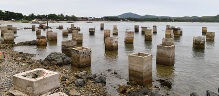 川と海が交わる入り江に、コンクリートで固められた無数の穴が並ぶ。１年前まで金採掘に使われていたが、新しい自治体長により使用が禁止され、多くの人が働く場所を失った＝フィリピン・カマリネスノルテ州パラカリエで
