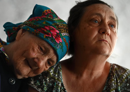祖国から共にモルドバに逃れてきた母（左）に寄り添うニナ・モシエンコさん＝モルドバのカルピネニで２０２２年５月２６日、山田尚弘撮影