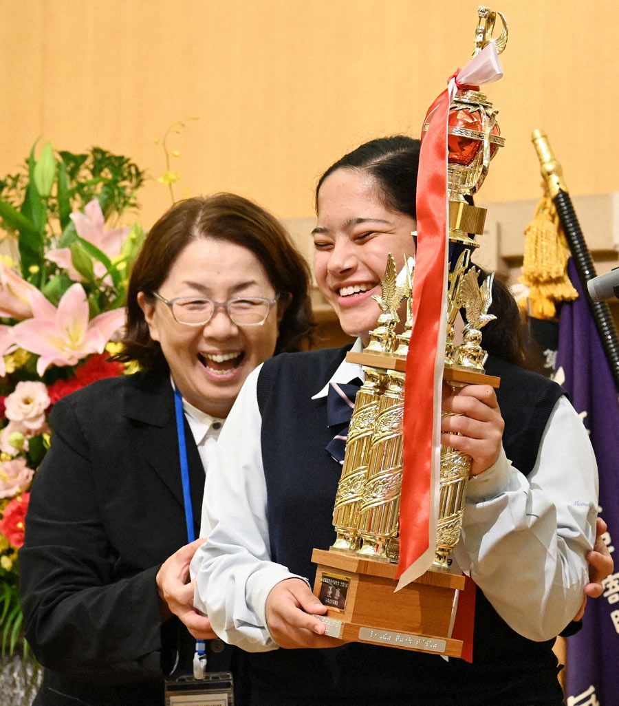 第92回全国盲学校弁論大会全国大会の優勝杯を受け取り､笑顔を見せるカーン･ファティマ･フランシスコさん